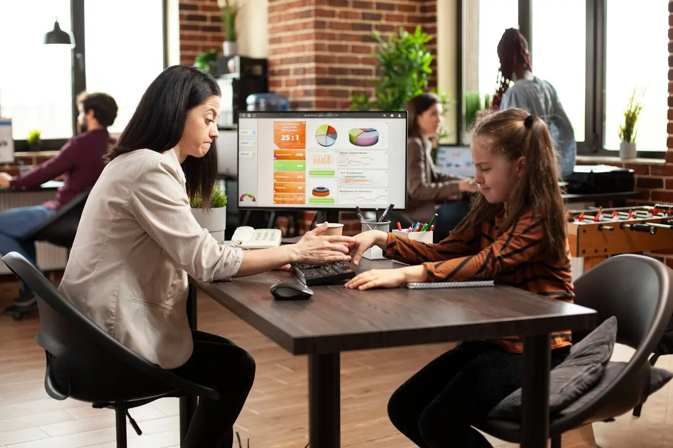 Игривая девочка отвлекает маму на работе.